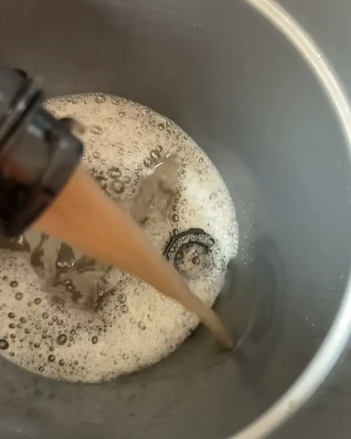 Brown, foamy dirty water from the job being poured into a bucket.