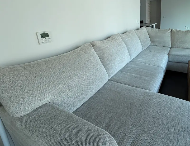 Large light-gray U-shaped sectional in a bright apartment after cleaning.